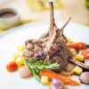 Exquisite plated lamb chops with colorful vegetables, showcasing fine gastronomy.